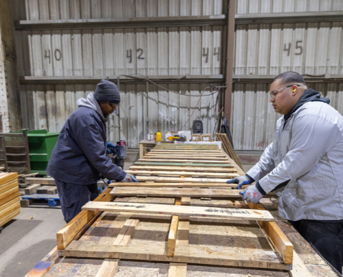 Image of two men building pallets